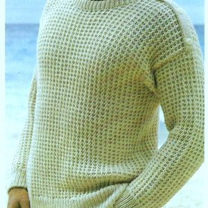 May include: A light beige knitted sweater with a waffle stitch pattern. The sweater has a crew neck and long sleeves.