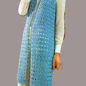 May include: A long, light blue crochet vest with a V-neck and a matching light blue crochet hat. The vest is open in the front and has a loose fit. The hat is a simple beanie style.