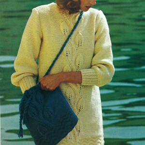 May include: A cream-coloured long-sleeve knit jumper featuring a vertical leaf-patterned texture, paired with a matching blue knit beanie and a blue knit shoulder bag with a drawstring closure and a similar leaf-patterned design on the front.