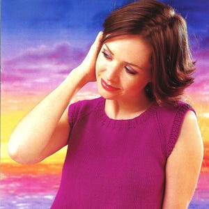 May include: A sleeveless, magenta-colored knitted top with a ribbed hem and neckline. The top has a simple, classic design, perfect for layering or wearing on its own. The model is wearing the top.