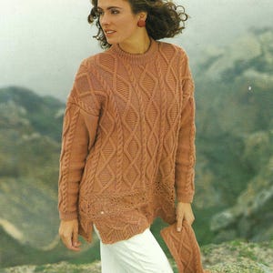 Peut inclure: Un pull en tricot torsadé marron à la coupe ample et plus long à l'avant. Le pull présente un motif en losange et une bordure en crochet au bas.