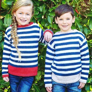 May include: Two children wearing blue and white striped sweaters with red trim. The girl has a braid in her hair. The boy is smiling.