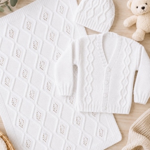 May include: A white knitted baby set consisting of a long-sleeve button-down cardigan, a matching beanie hat, and a rectangular blanket. The cardigan and blanket feature a diamond-shaped openwork pattern, while the beanie has a cable knit design.