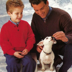 Puede incluir: Un niño con un suéter rojo y jeans azules está sentado junto a un hombre con un suéter marrón. Un perro blanco pequeño con un collar marrón mira al hombre. El fondo tiene un diseño azul y blanco.