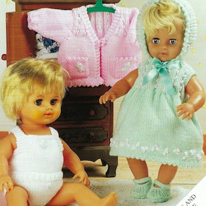 Puede incluir: Dos muñecas con atuendos tejidos. La muñeca de la izquierda lleva un mono tejido blanco. La muñeca de la derecha lleva un vestido tejido verde con una capucha blanca y botines tejidos a juego. El texto "FOR DOLLS AND PREMATURE BABIES" es visible en la esquina inferior derecha de la imagen.