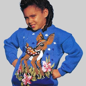 May include: A blue knitted sweater with a brown deer and flowers embroidered on the front. The deer is wearing a white scarf and has a brown and white spotted pattern.