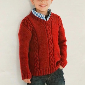 May include: A red knitted sweater with a cable knit pattern. The sweater has a round neckline and long sleeves.