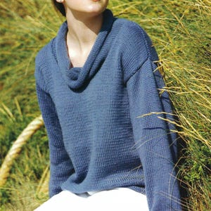 May include: A blue cowl neck sweater with long sleeves. The sweater is made of a soft, textured fabric.