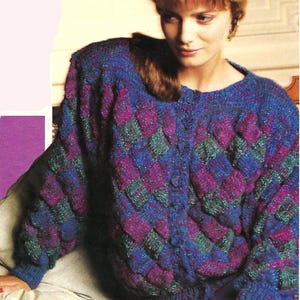 Könnte beinhalten: Gestrickte Strickjacke mit Rautenmuster in Blau-, Lila- und Grüntönen. Der Cardigan zum Knöpfen hat einen runden Ausschnitt und lange Ärmel. Das Kleidungsstück wird mit einem blauen Rock getragen.