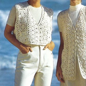 Peut inclure: Deux femmes portant des gilets en crochet blanc. Les gilets ont un motif en dentelle et sont sans manches. Les femmes sont debout sur une plage avec l'océan en arrière-plan.