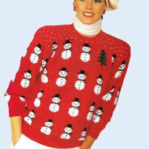 May include: A red knitted sweater with a snowman pattern. The sweater has a white turtleneck collar and long sleeves. The model is wearing a white beret with a red stripe.