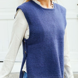 May include: A blue knitted sleeveless vest with a round neckline and button closures on the sides.