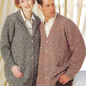 May include: A woman and a man are wearing knitted cardigans. The woman's cardigan is grey and buttoned, while the man's is brown with a V-neck and pockets. Both are wearing collared shirts underneath.