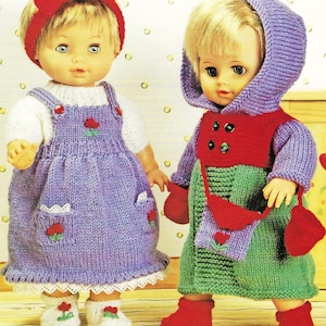 Könnte beinhalten: Zwei gestrickte Puppenoutfits, eines in Lila mit einem weißen Oberteil und roten Blumen, das andere in Grün mit einer roten Kapuzenjacke und einer roten Tasche.