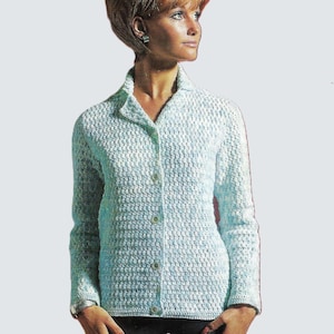 May include: A light blue, long-sleeved crochet cardigan with a collared neckline and button-down front. The cardigan has a textured, all-over pattern. The woman in the image is wearing the cardigan.