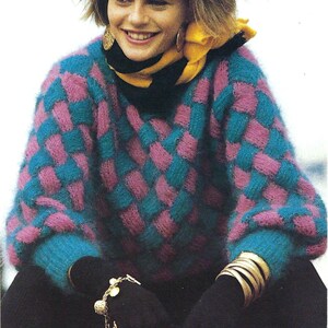 May include: A fluffy, pink and teal checked jumper with a yellow scarf and gold bracelets.