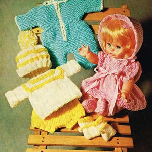 Peut inclure: Un ensemble de vêtements tricotés pour poupée, comprenant une combinaison tricotée bleue, un pull et un pantalon tricotés blanc et jaune, un bonnet tricoté blanc et jaune et une paire de chaussons tricotés blanc et jaune.
