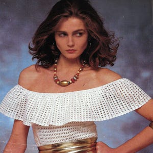 Puede incluir: Un top blanco de crochet de hombros descubiertos con un escote con volantes y un cinturón dorado.