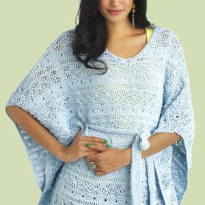 May include: A light blue knitted top with a loose, flowing fit and a tie belt. The top has a delicate openwork pattern and a V-neck.