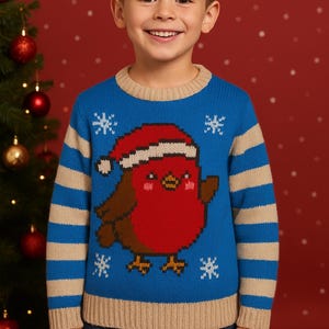 Könnte beinhalten: Ein blauer Strickpullover mit einem Cartoon-Rotkehlchen, das einen Weihnachtsmannhut und Schneeflocken trägt. Der Pullover hat beige Streifen auf den Ärmeln und einen beigen Ausschnitt und Saum. Getragen von einem Kind.