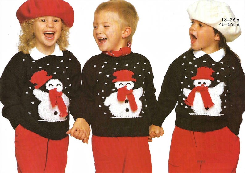May include: Three children wearing black sweaters with white snowflakes and a white snowman with a red hat and scarf. The sweaters are for ages 18-26 inches or 46-66 centimeters.