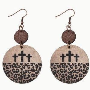 May include: A pair of wooden earrings with a brown top and a beige bottom. The bottom features three black crosses and a leopard print pattern.