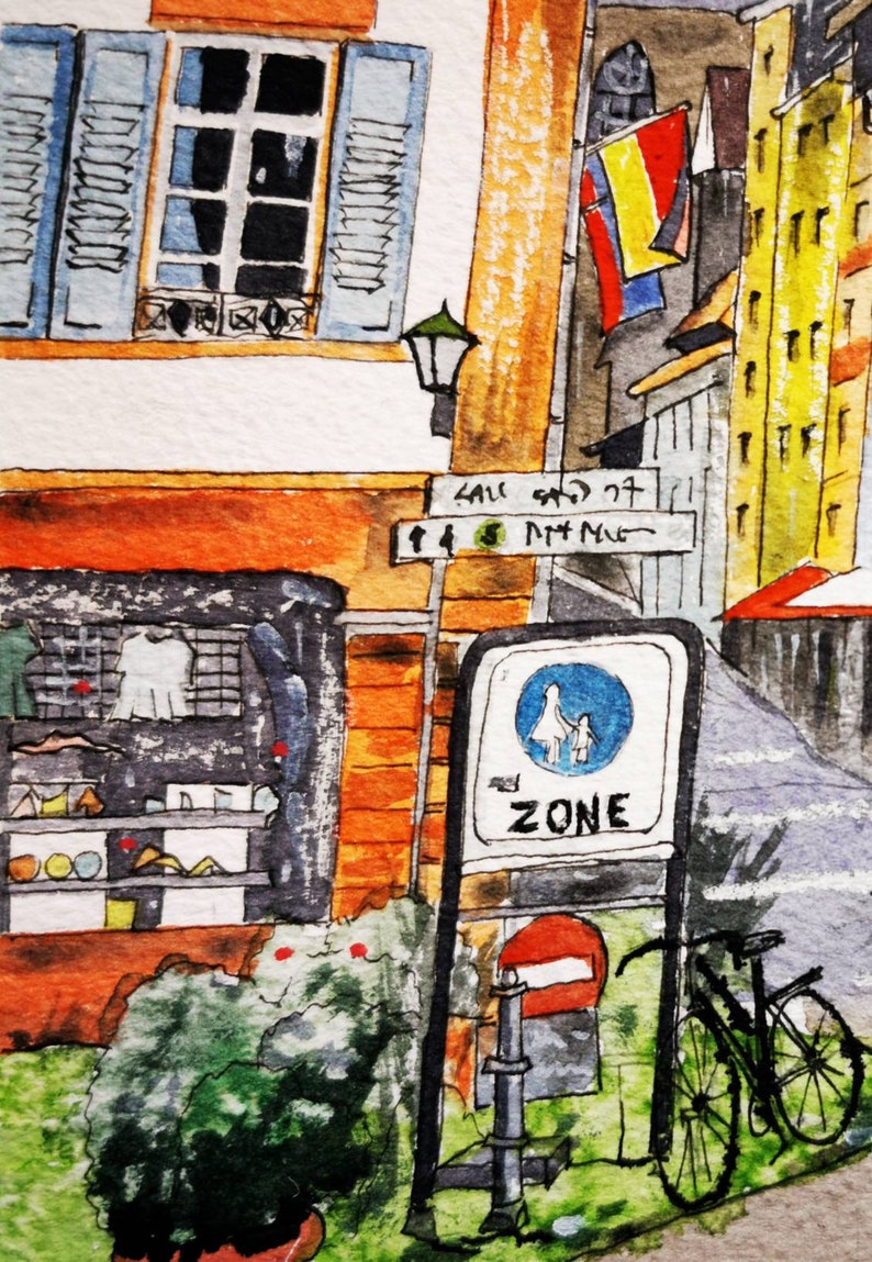 May include: Watercolor painting of a European street scene. Features a storefront, street signs, a bicycle, and a pedestrian zone sign. Buildings are painted in shades of orange, yellow, and blue. The street sign reads "SAU ST" and "ZONE".