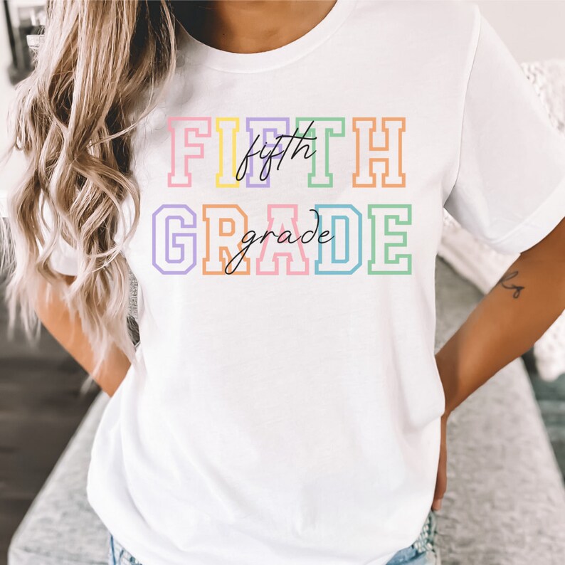 K&ouml;nnte beinhalten: Wei&szlig;es T-Shirt mit dem Text "FIFTH grade" in Regenbogenfarben mit schwarzem Umriss.