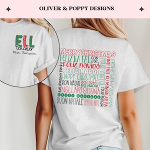 Könnte beinhalten: Weißes T-Shirt mit einem grün-roten Design auf der Rückseite, das in mehreren Sprachen "Frohe Weihnachten" sagt. Die Vorderseite des Shirts hat ein grün-rotes Design, das "ELL teacher" und "Miss. Thompson" sagt.