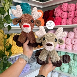 Może przedstawiać: Dwie pluszowe zabawki w kształcie reniferów, jeden brązowy i jeden beżowy, z białymi rogami i czerwonymi nosami. Zabawki są ręcznie robione i mają czarne oczy. Obraz zawiera tekst "PDF PATTERN ONLY".