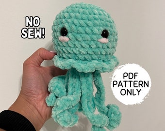 May include: A crocheted jellyfish amigurumi toy with a teal blue body, pink cheeks, and black eyes. The toy is held in a hand and the text "NO SEW!" and "PDF PATTERN ONLY" are visible in the image.