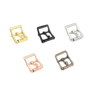 Puede incluir: Cinco hebillas metálicas en varios colores: dorado, negro, plateado, oro rosa y bronce. Cada hebilla tiene un marco rectangular con una barra central y un pasador para asegurar correas. Se muestran sobre fondo blanco.