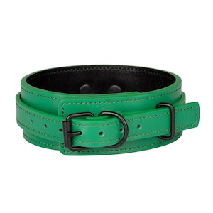 May include: A bright green leather collar featuring a black interior lining and matte black hardware. The collar includes a buckle, a D-ring, and a belt loop, all secured with matching green stitching along the edges of the leather strap.