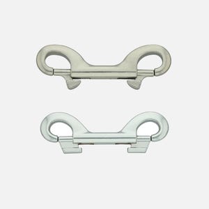 May include: Two double-ended bolt snaps made of metal. The top snap has a matte, brushed silver finish, while the bottom snap features a polished, shiny chrome-like finish. Both hardware pieces have spring-loaded gates on each end for attachment.
