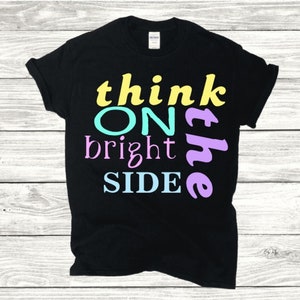 May include: Black t-shirt with the text "think on the bright side" in yellow, blue, pink, and purple.