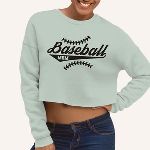 May include: A light blue cropped sweatshirt with a black baseball graphic and the text "Baseball Mom".