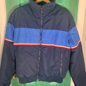 May include: A blue, red, and white striped vintage puffer jacket with a zipper closure.