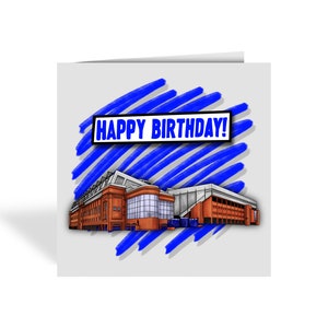 May include: A birthday card featuring a detailed illustration of a stadium with orange and blue accents. The card has a white background with blue brushstrokes and the text "HAPPY BIRTHDAY!" in a blue and white box.