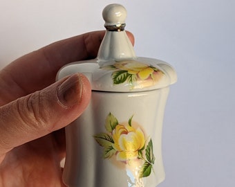 Vintage porcelain trinket box with yellow roses, perfect for rings, earrings, and small mementos