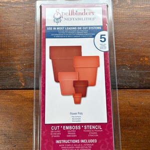 May include: A Spellbinders Nestabilities package containing five flower pot shaped metal cutting dies. The packaging is white and magenta with text reading Use in Most Leading Die Cut Systems, Flower Pots, and Cut Emboss Stencil.