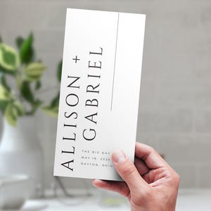 Puede incluir: Una invitación de boda blanca con texto negro que dice "Allison + Gabriel" y "The Big Day May 18, 2026 Dayton, Ohio".