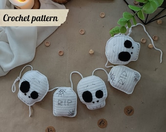 May include: A white crocheted garland with four skull shapes and two tombstones. The tombstones have the word "RIP" and a spiderweb design. The garland is perfect for Halloween decorations.