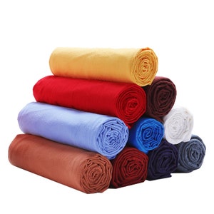 May include: A stack of rolled fabric in various colours, including yellow, red, blue, brown, and white.