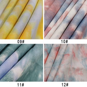 Pu&ograve; includere: Quattro campioni di tessuto con motivi tie-dye in diverse combinazioni di colori. I campioni sono etichettati con i numeri 09, 10, 11 e 12.
