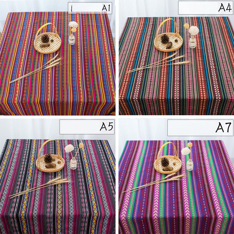 May include: Four different striped tablecloths with various colors and patterns. The tablecloths are made of a woven fabric and have a fringed edge. The tablecloths are displayed on a table with a basket and a vase.
