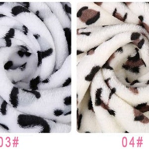 May include: Two close-up images of white fabric with a black and brown leopard print. The first image has a black print and the second image has a brown print.