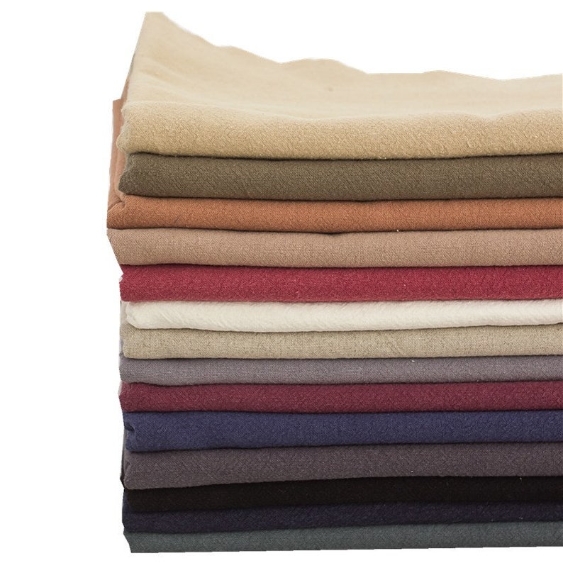 May include: A stack of 14 fabric swatches in various colours, including beige, brown, red, white, grey, burgundy, navy, black, and teal.
