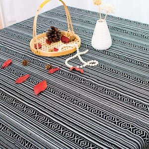 May include: Black and white striped tablecloth with a geometric pattern. The tablecloth is made of cotton and is perfect for a casual dining experience.