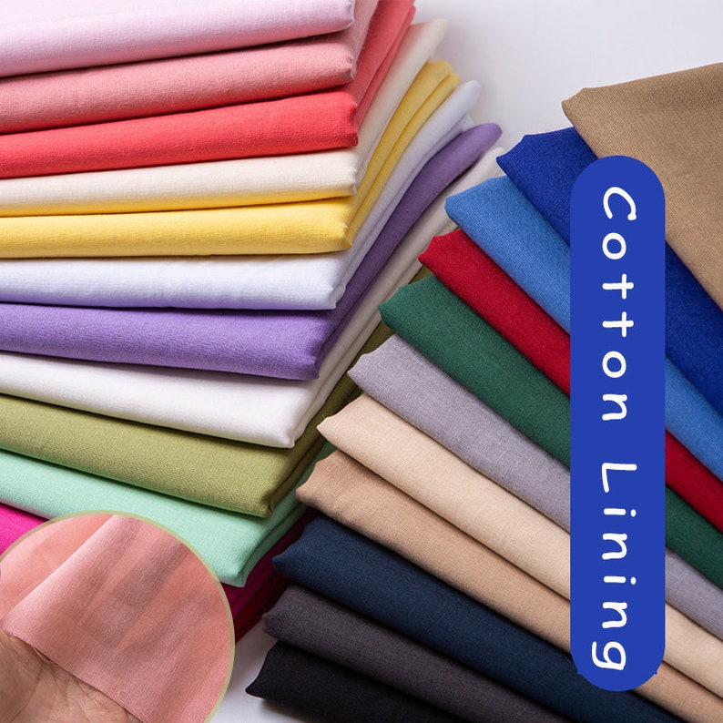 May include: A stack of various coloured cotton lining fabric swatches. The fabric is smooth and has a subtle texture. The text "Cotton Lining" is written in blue on a white background.