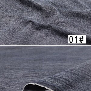Puede incluir: Primer plano de una tela vaquera gris oscuro con una superficie texturizada. La tela est&aacute; doblada por la mitad, mostrando el interior de la tela, que es de color gris m&aacute;s claro. La tela est&aacute; etiquetada con "01#"